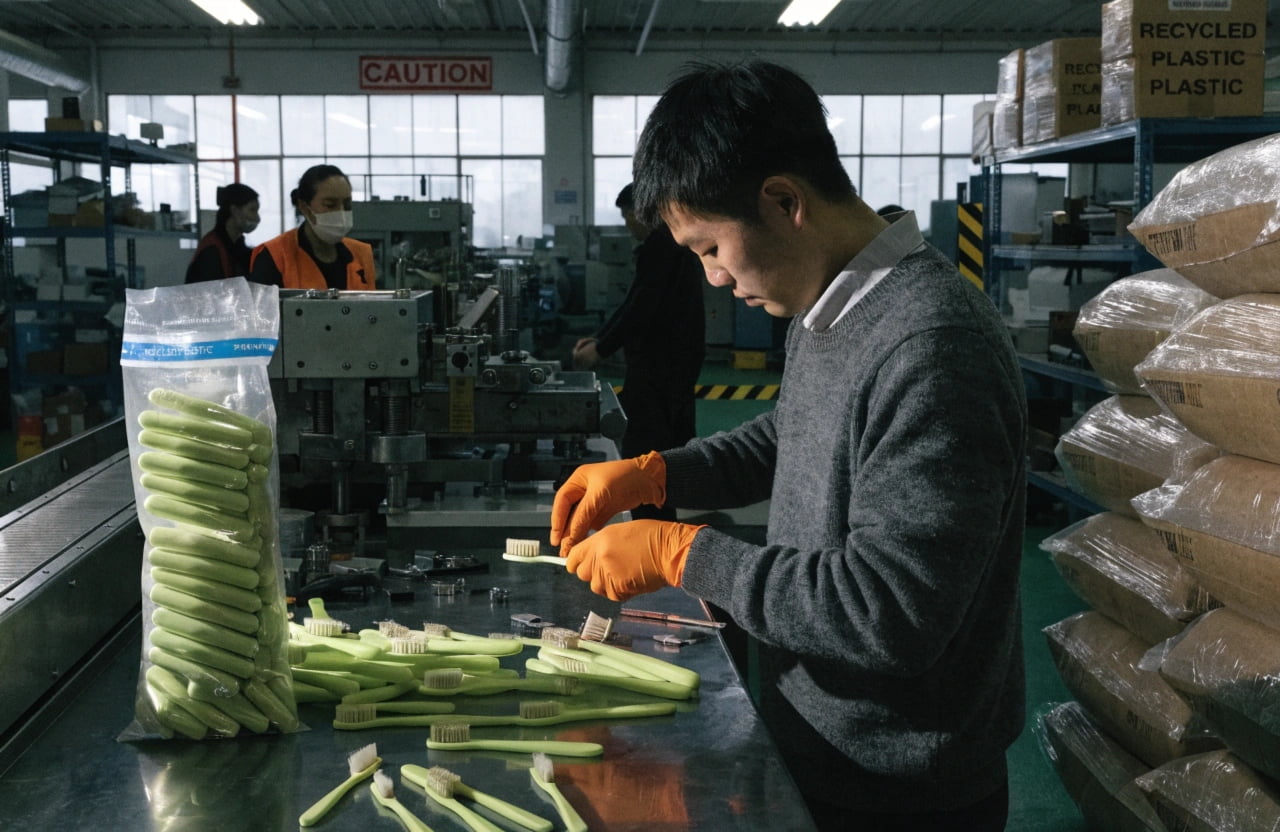 Challenges in Sustainable Manufacturing A factory floor with workers assembling toothbrushes
